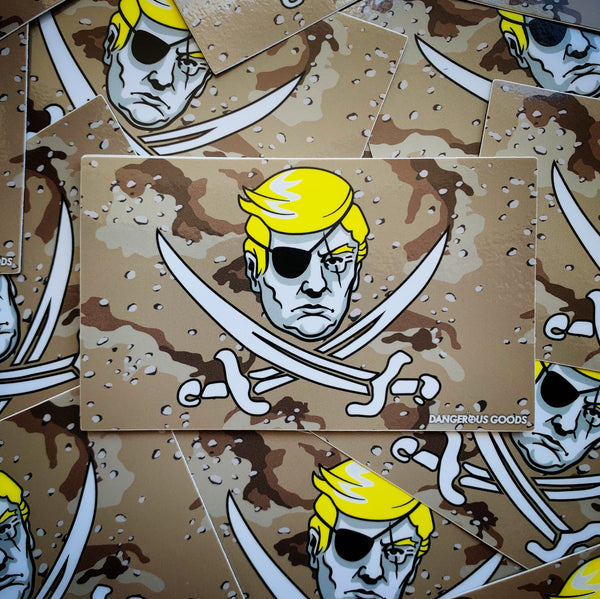Tan desert storm style camo flag sticker depicting a cartoon image of trumps head with two crossing pirate swords underneath 