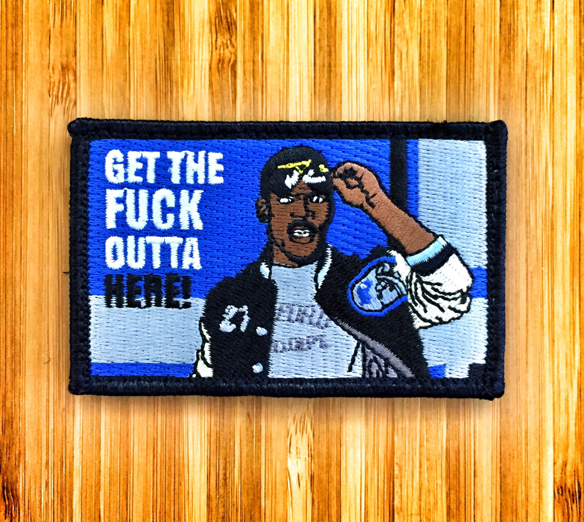 Embroidered patch depicting a man holding sunglasses above his head with text that reads Get the fuck outta here