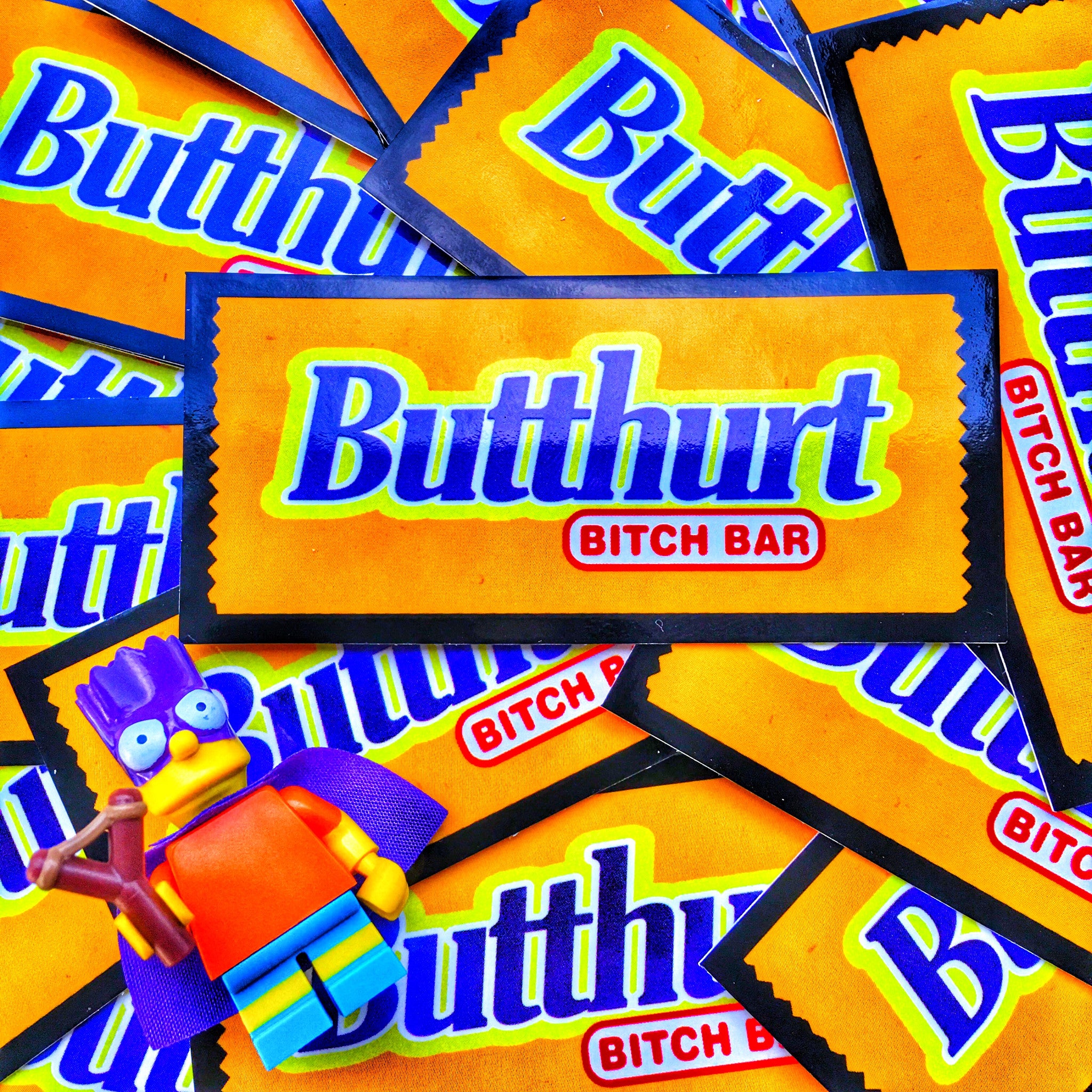 Yellow and blue candy bar shaped vinyl sticker with text that reads Butthurt bitch bar 